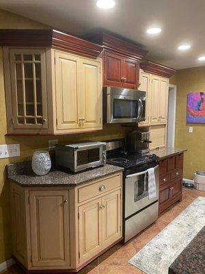 Before: Mixed wood custom cabinets with storage drawers and glass display cabinets