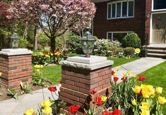 Brick columns with stone walkway. Landscaping and exterior lighting.