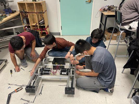 Team taking apart a robot