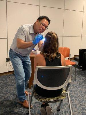 Dr. Nguyen doing athlete dental exams at the University of Texas at Arlington