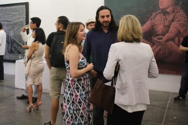 Visiters talking with the artist, Alexi Torres (center.)