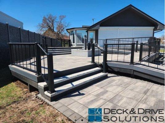 Stone deck with ramps, custom water feature. and upgraded cable railing.