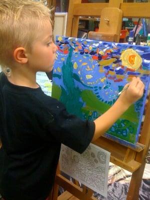 6 year old student painting their interpretation of Stary Night.