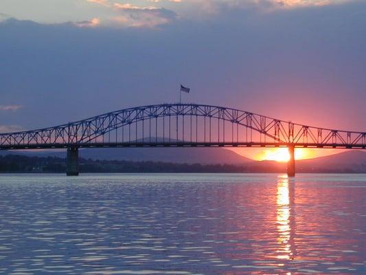 Sunset behind the blue bridge from the water