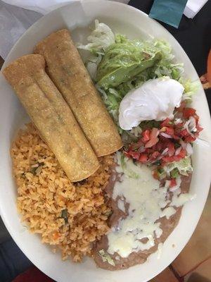 Chicken flautas with rice, beans and salad/toppings.