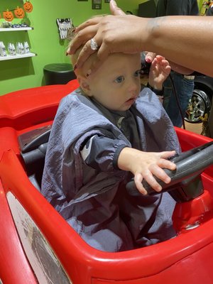 Getting his hair cut in the car.