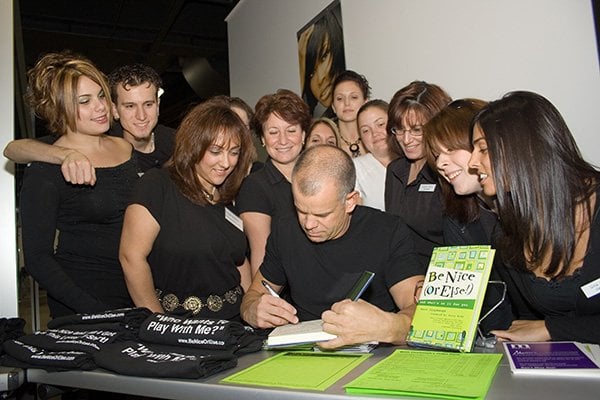 Winn Claybaugh signs copies of his book, "Be Nice Or Else" with Future Professionals looking on.