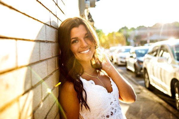 High School Senior posing with glow of the sun in the background