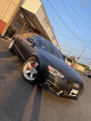 Jet black wrap with gloss black roof and red caliper.