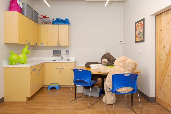 Two large stuffed animals sitting at a table in a therapy space at DFX