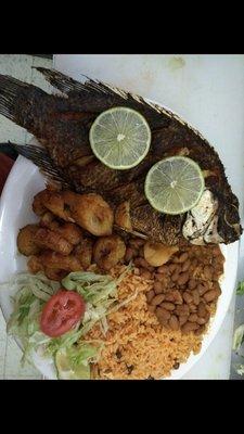 Fried fish platter with yellow rice salad fried bananas and beans