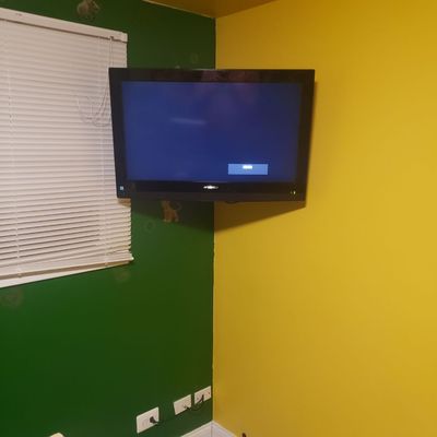 Tv mounted in the corner with wires hidden.