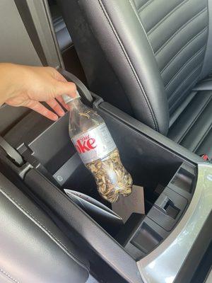 Coke bottle with used sunflower seeds and documents of other renters with personal identifying info on them