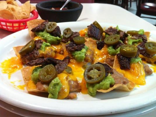 Chachos - fajita, refried beans, guacamole, melted cheese, and jalapeños