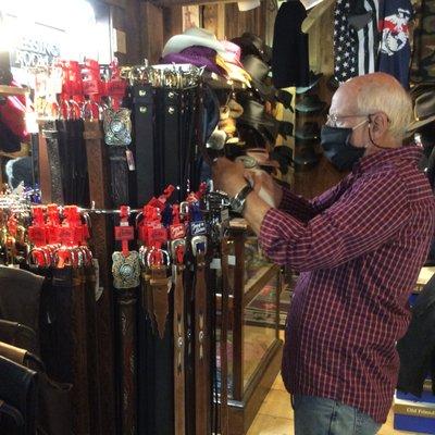 Tom, shop owner, organizing new belts.