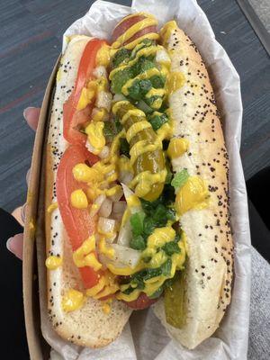 Chicago Style Hot Dog with fresh toppings: tomatoes, pickled peppers, green relish, onions, and some yellow mustard.