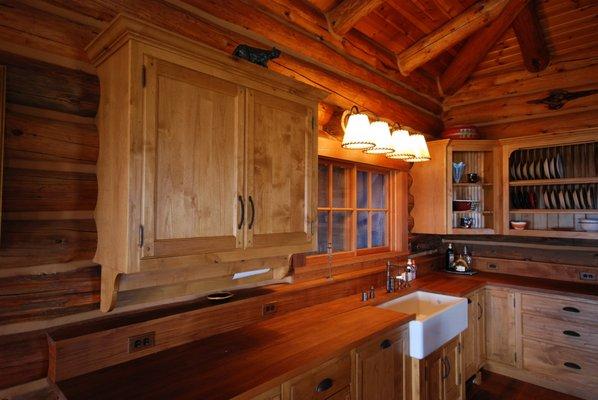 Teak counter tops with Shaw farmhouse sink.  This custom built kitchen fit this rustic cabin beautifully. Note the beamed walls.