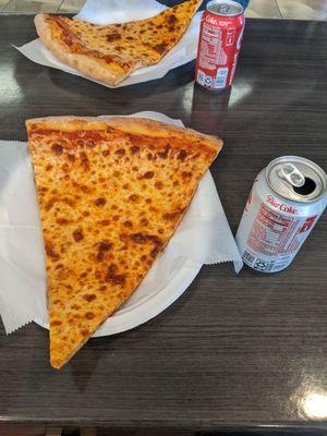 Pizza slices with soda cans for scale