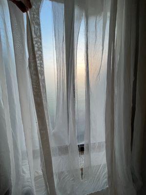 Ripped curtains. Plastic covering window from outside but no idea why.