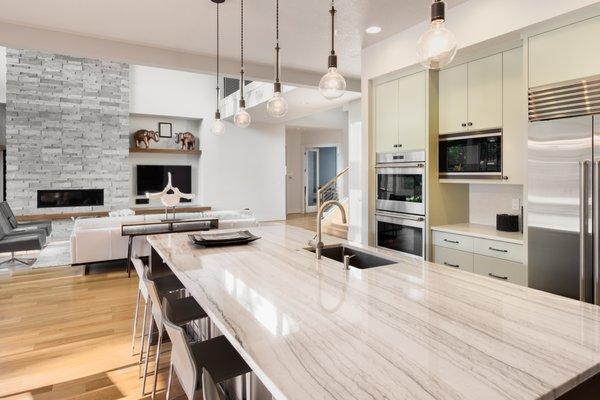 Luxury kitchen with island, sink, cabinets and hardwood floors. This room offers open concept of living room, cozy fireplace and TV.