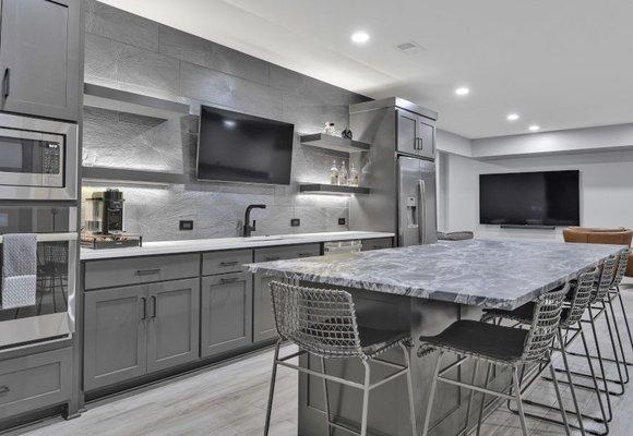 Contemporary look achieved with soft gray cabinets, LVP flooring, backsplash tiles & quartz countertops.