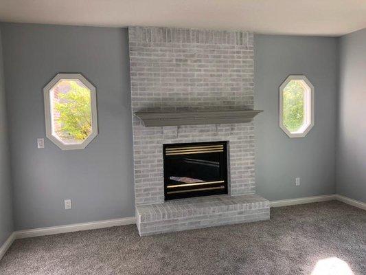 Red, and smoked stained brick converted to modern gray undertones. Converted mantle as well.  Really opens up the room.