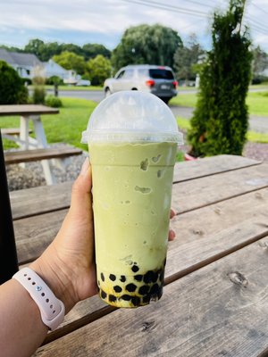 Frozen Matcha Slushy with boba. Topped with whipped cream!