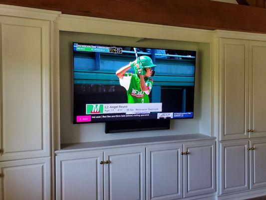 75" TV on a tilting wall mount & a Sonos Playbar attached the TV with AV equipment located inside cabinetry (Rancho Palos Verdes).