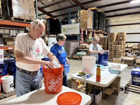 Volunteers in the Disaster Relief Center packing flood buckets for emergency response.