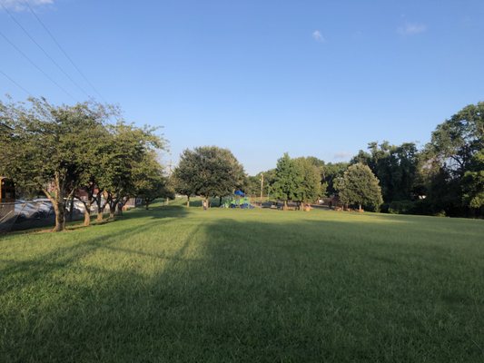 Large lawn with a fence before Gallatin Pike