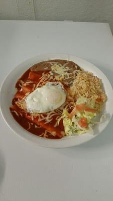 Red enchiladas with egg on top. And rice &  beans