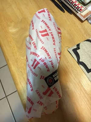 Barely wrapped sandwich after horrible service.